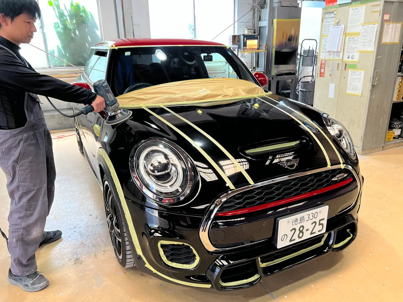 自動車のボデーを丁寧に磨く熟練スタッフ
